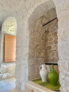 kamienna ściana z dwoma wazami siedzącymi na stole w obiekcie I Trulli del Vagabondo - Complex of Trulli with Private Pool w Alberobello
