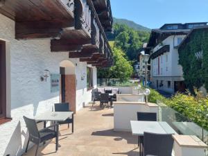 a patio with tables and chairs on a building at Hotel Seerose Wolfgangsee in St. Wolfgang