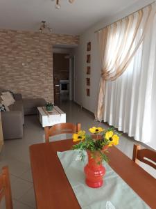 una sala de estar con una mesa con flores amarillas. en Igli apartments, en Arkasa