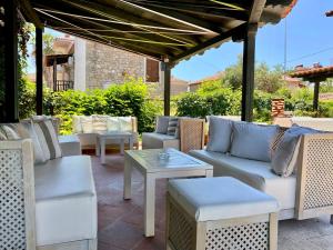 un patio con sillas, mesas y una pérgola en Eden Hotel, en Afitos