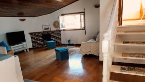 un salon avec un escalier et une cheminée dans l'établissement Casa Milia Orange, à Marinhas