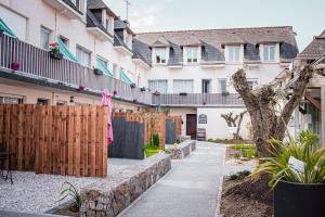 a garden with a wooden fence and a sidewalk at L'Auberg'ine - Maison Glenn Anna in Sainte Anne d'Auray