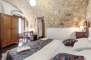 ein Schlafzimmer mit einem großen Bett und einer Steinmauer in der Unterkunft Locanda La Meridiana in Ragusa