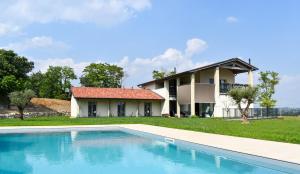 a villa with a swimming pool in front of a house at Bed and Breakfast Le Giale in Castelnuovo del Garda