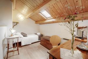 a bedroom with a bed and a desk and a table with a vase at Locanda La Meridiana in Ragusa