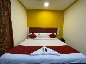 a bedroom with a large bed with red pillows at Skyry Hotels Adyar in Chennai