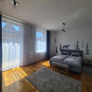 ein Schlafzimmer mit einem Bett und einem großen Fenster in der Unterkunft Kamieniec No5 Apartments in Zakopane