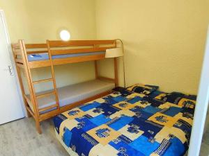 a bedroom with a bunk bed and a ladder at Appartement Cauterets, 2 pièces, 6 personnes - FR-1-234-130 in Cauterets