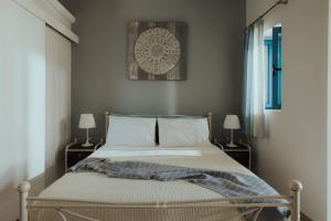 a bedroom with a bed and a clock on the wall at Sea Mansion Lefkada in Nikiana