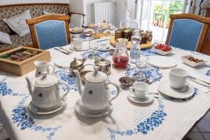 a table with teapots and cups and plates on it at Locanda La Meridiana in Ragusa