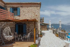 a house on the beach with a table and chairs at Sea Mansion Lefkada in Nikiana
