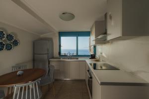 a kitchen with a table and a sink and a window at Sea Mansion Lefkada in Nikiana