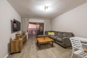 una sala de estar con un sofá y una mesa en Beacon Wharf , George Hay 3 Holiday Accommodation, en Mossel Bay
