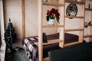 Una habitación con una cama en una cabaña con un árbol de Navidad en Ecottage котедж для двох у горах із чаном-джакузі, en Slavske