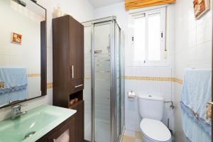 La salle de bains est pourvue de toilettes, d'un lavabo et d'une douche. dans l'établissement BrisaMar I en segunda línea de playa & priv parking, à Torre de Benagalbón