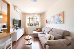 a living room with a couch and a kitchen at Estupendo apartamento en segunda línea de playa in Torre de Benagalbón
