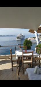 ein Kreuzfahrtschiff im Wasser mit einem Tisch und Stühlen in der Unterkunft Titania Hotel in Sarandë