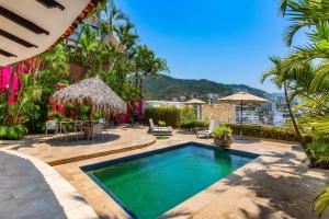 una piscina en medio de un patio con palmeras en Gorgeous, Lovely Home at Casa Ciclamor, en Puerto Vallarta