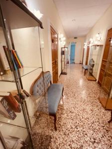 a hallway with a chair and a glass shelf at Hotel Baia di Levanto in Levanto