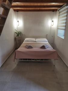 een slaapkamer met een bed met een roze deken bij Elaion Thea2-Nies in Soúrpi