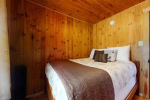 a bedroom with a bed in a wooden wall at Lake House Retreat in Ossipee