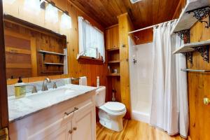 a bathroom with a white sink and a toilet at Lake House Retreat in Ossipee +32 photos