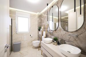 uma casa de banho com 2 lavatórios e um espelho em Olive Residence em Zadar