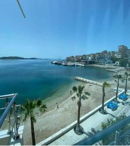 een uitzicht op een strand met palmbomen en de oceaan bij Titania Hotel in Sarandë