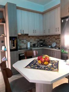a kitchen with a table with a bowl of fruit on it at Renovated flat with huge balcony - Ανακαινισμένο διαμέρισμα με τεράστιο μπαλκόνι in Karditsa
