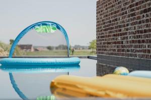 a swimming pool with an arch in the water at Landhuis Eikenburg in Ieper
