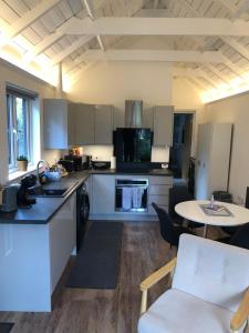 a kitchen with white cabinets and a table and chairs at Unique one bed contemporary bungalow town centre in March