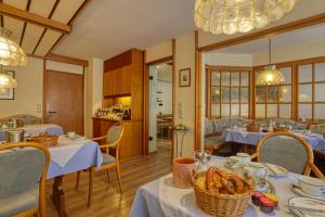 a restaurant with tables and chairs with food on them at Hotel Jakob in Füssen