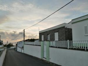 an empty street with a building and a fence at Casa Dos Mosteiros in Mosteiros