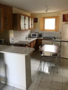 a kitchen with a table and chairs in it at Studio Meublé in Saint-Thibéry