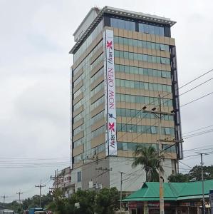 a tall building with a sign on the side of it at Hotel X Narsingdi in Mādhabdi