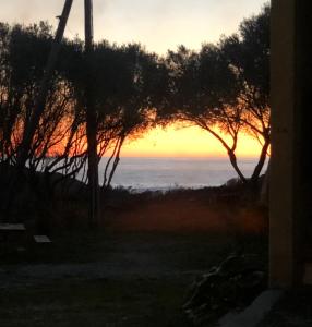 una vista sul tramonto dalla finestra di una casa di Résidences Anna a Centuri