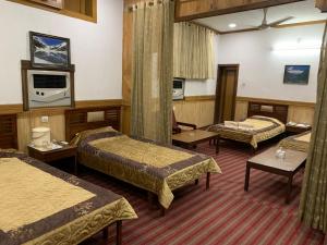 A bed or beds in a room at Park Hotel Gilgit