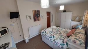 a small bedroom with a bed and a microwave at Tennyson Lodge in Mablethorpe