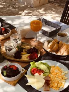 une table avec des plaques alimentaires et un verre de jus d'orange dans l'établissement Art Hotel Galathea, à Kotor