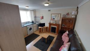 a living room with a couch and a kitchen at Tennyson Lodge in Mablethorpe