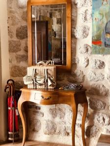 una mesa de madera con un espejo en una pared de piedra en Art Hotel Galathea, en Kotor