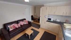 a living room with a couch and a kitchen at Tennyson Lodge in Mablethorpe