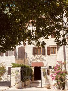 ein weißes Backsteingebäude mit einer Tür und einem Baum in der Unterkunft Art Hotel Galathea in Kotor