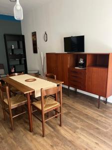uma sala de estar com uma mesa de madeira e uma televisão em Appartamento Mela ad Alba, cuore delle Langhe em Alba