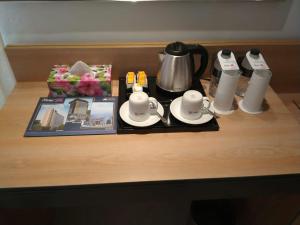 uma mesa com uma cafeteira e chávenas e uma revista em Hotel X Narsingdi em Mādhabdi