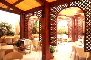 a dining room with tables and chairs in a restaurant at Hotel Flora in Cagliari