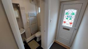 a bathroom with a toilet and a door with a window at Tennyson Lodge in Mablethorpe