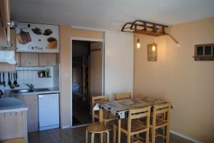 a kitchen with a table and chairs in a room at Appartement au pied des pistes in La Mongie