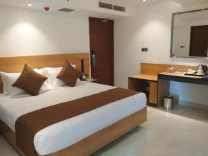 a bedroom with a bed and a desk and a mirror at Hotel X Narsingdi in Mādhabdi +6 photos
