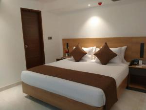 um quarto com uma cama grande num quarto de hotel em Hotel X Narsingdi em Mādhabdi